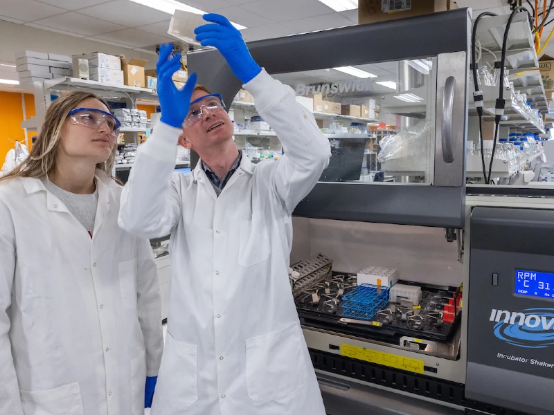 professor working with student in lab wearing labcoats