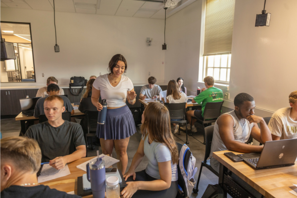 Students chat around tables in the new First Year Experience Lab.