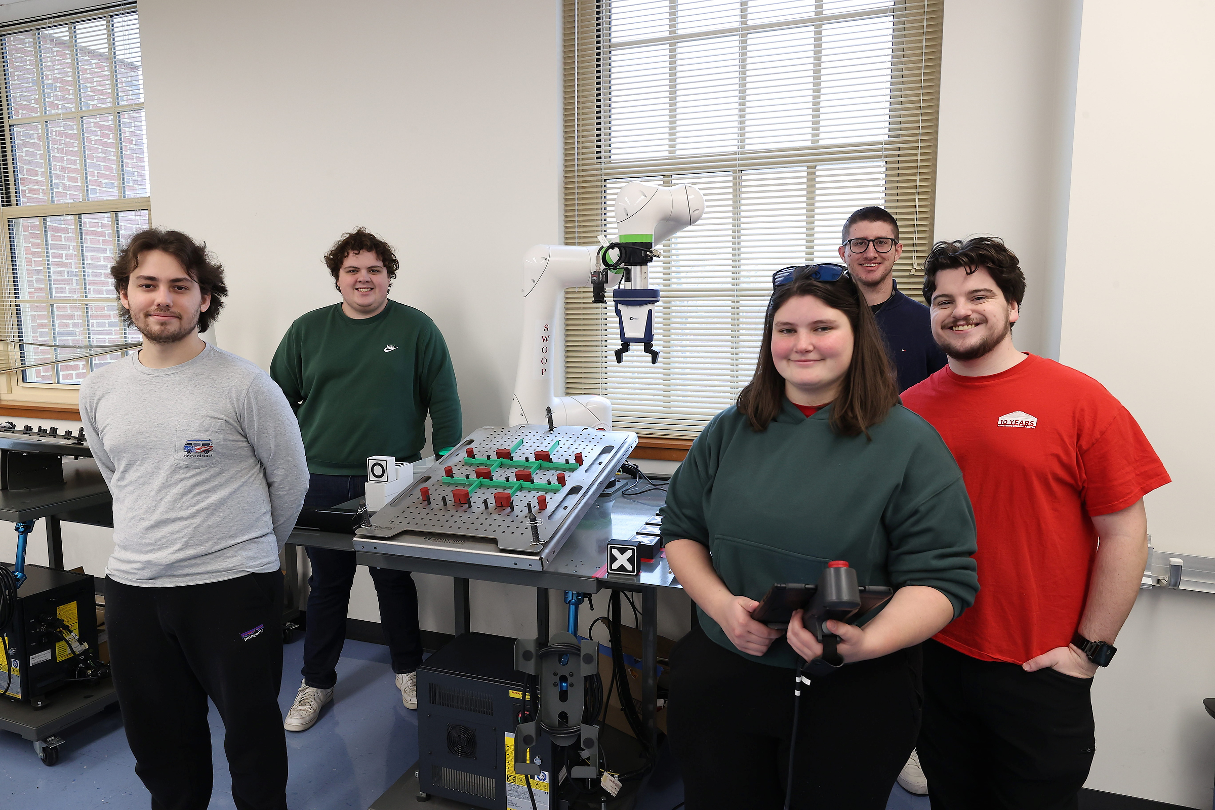 Parker Murphy, Jacob Bowens, Sami Friend, Carlo Buelvas, Ethan Chapel, and the robot they programmed to play Tic-Tac-Toe.