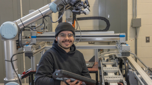 Abed Cabrera '24 manages controls for a robotic arm at Miami University's College of Engineering and Computing