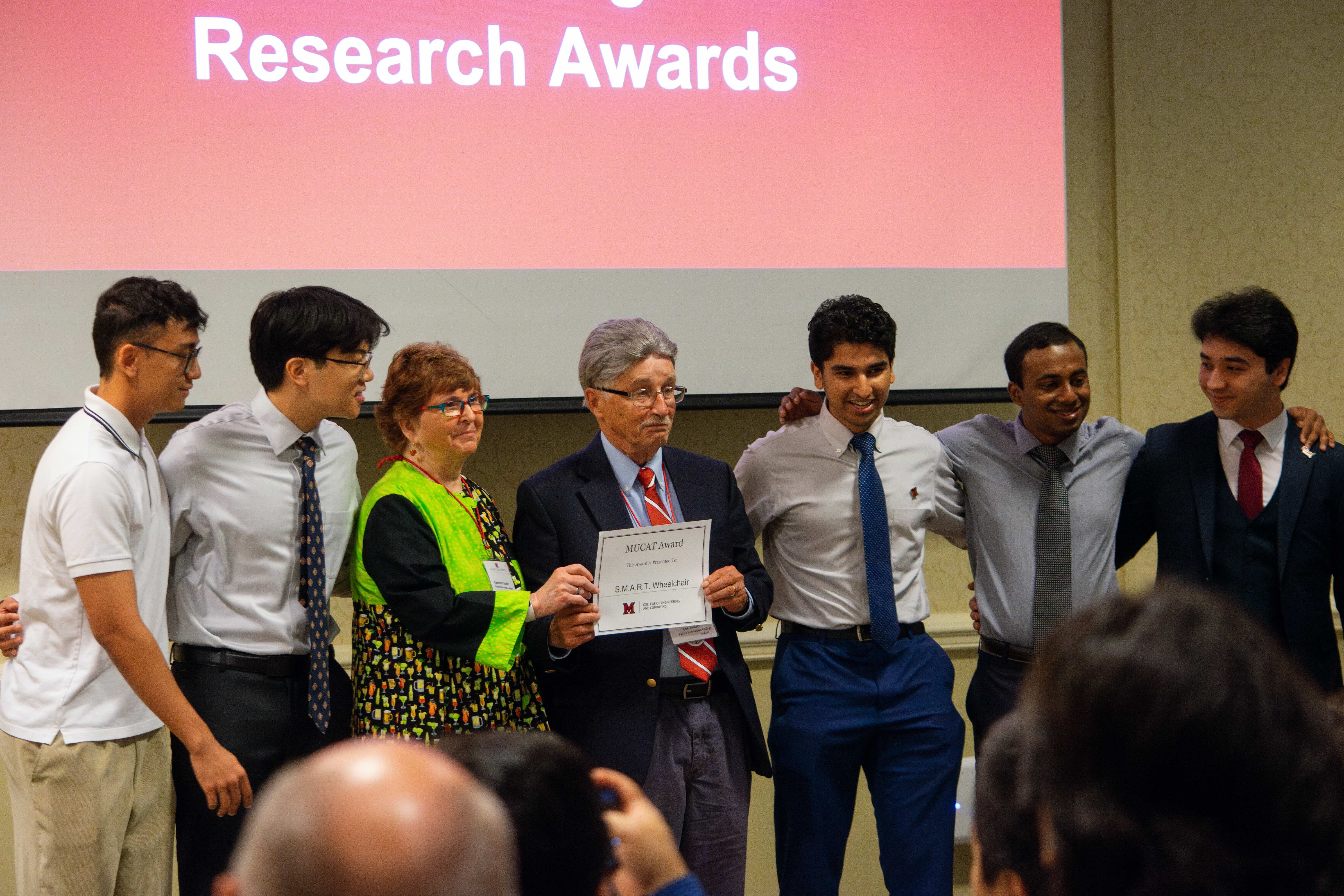 Lee and Rosemary Fisher stand with the MUCAT winning team with their award certificate.