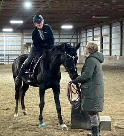 Laurie Edwards riding a horse while wearing a helmet.