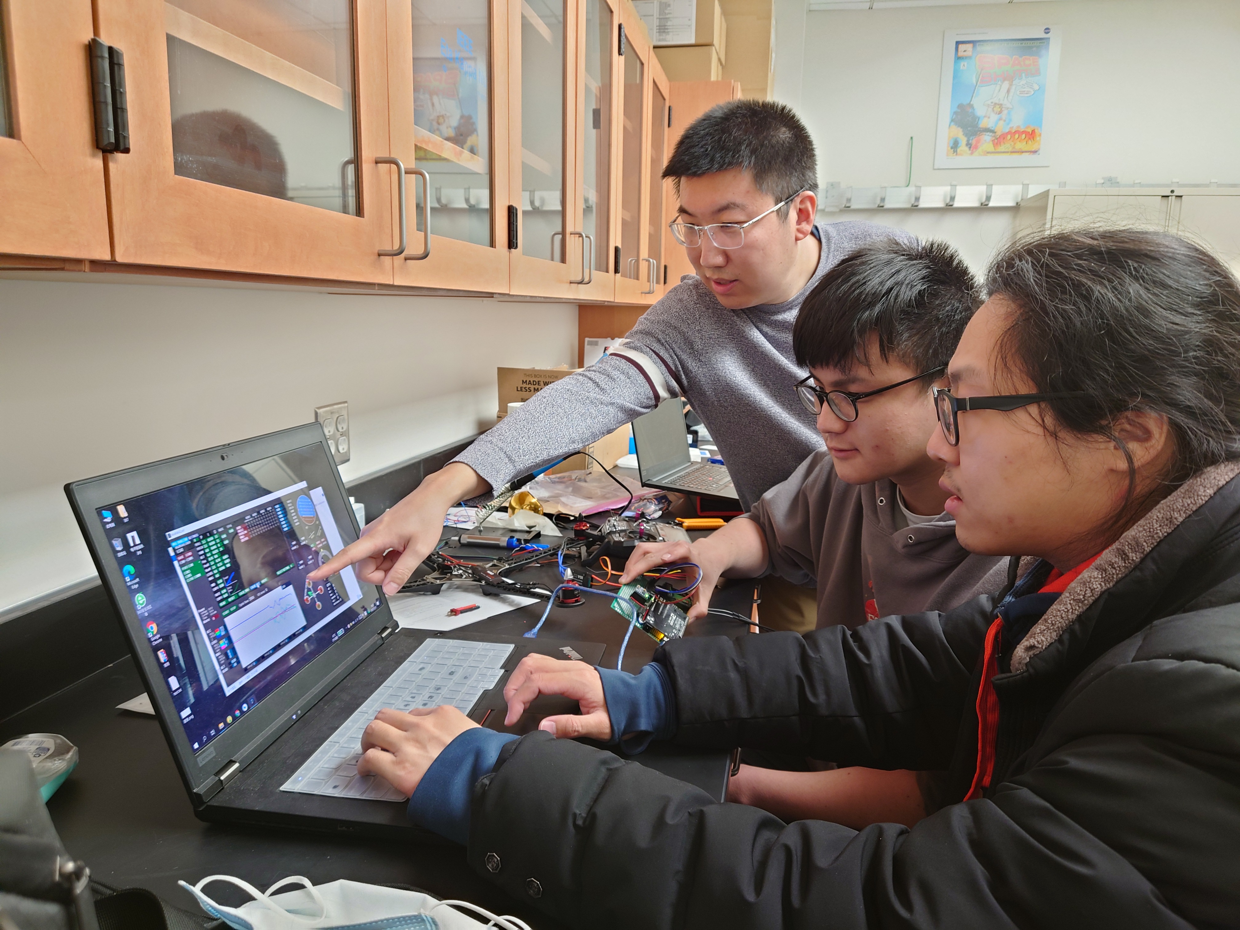 Ran Zhang, an assistant professor in the Department of Electrical and Computer Engineering, is in the lab with students.