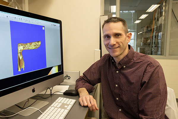 Justin Saul with a computer showing a bone construct