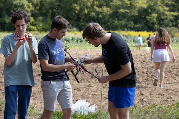 Bradley Gartner, left, with Robotics and Automation Club members on the Miami Farm.