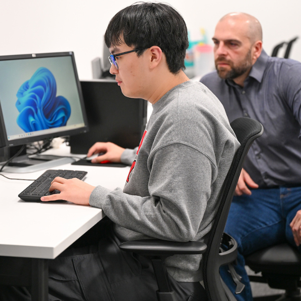 John Femiani and graduate student Ethan Han work at computer