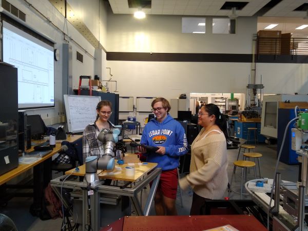 Three students working in an automation lab.