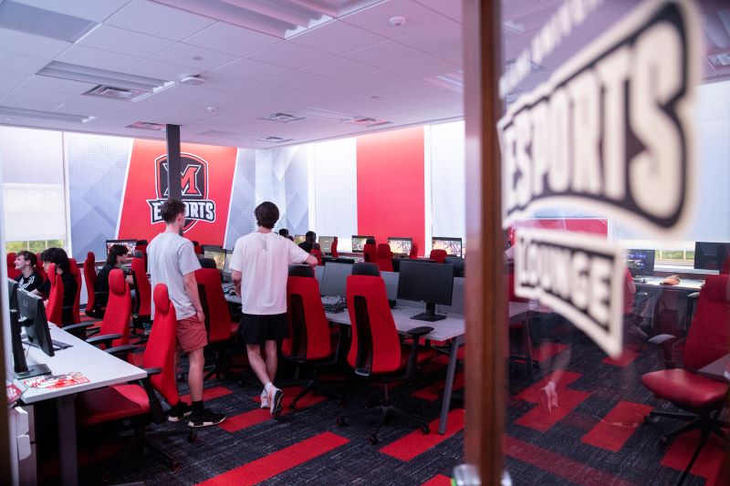 students standing in a room of computers laughing and playing 