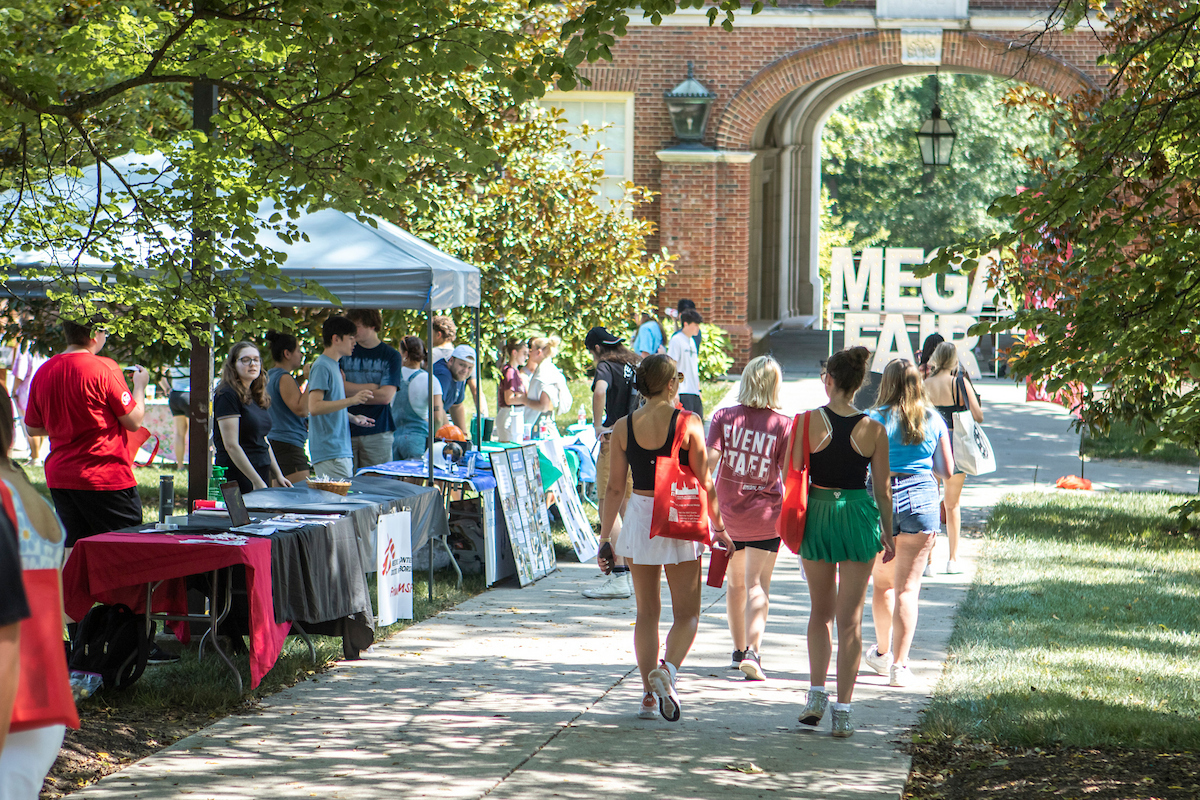 students walking down the side walk during a fair