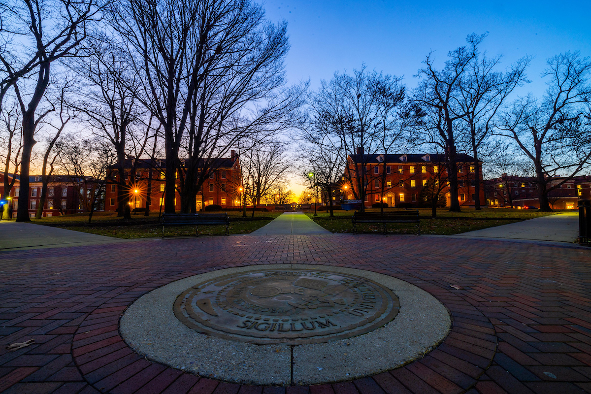 seal on the academic quad shown at sunset