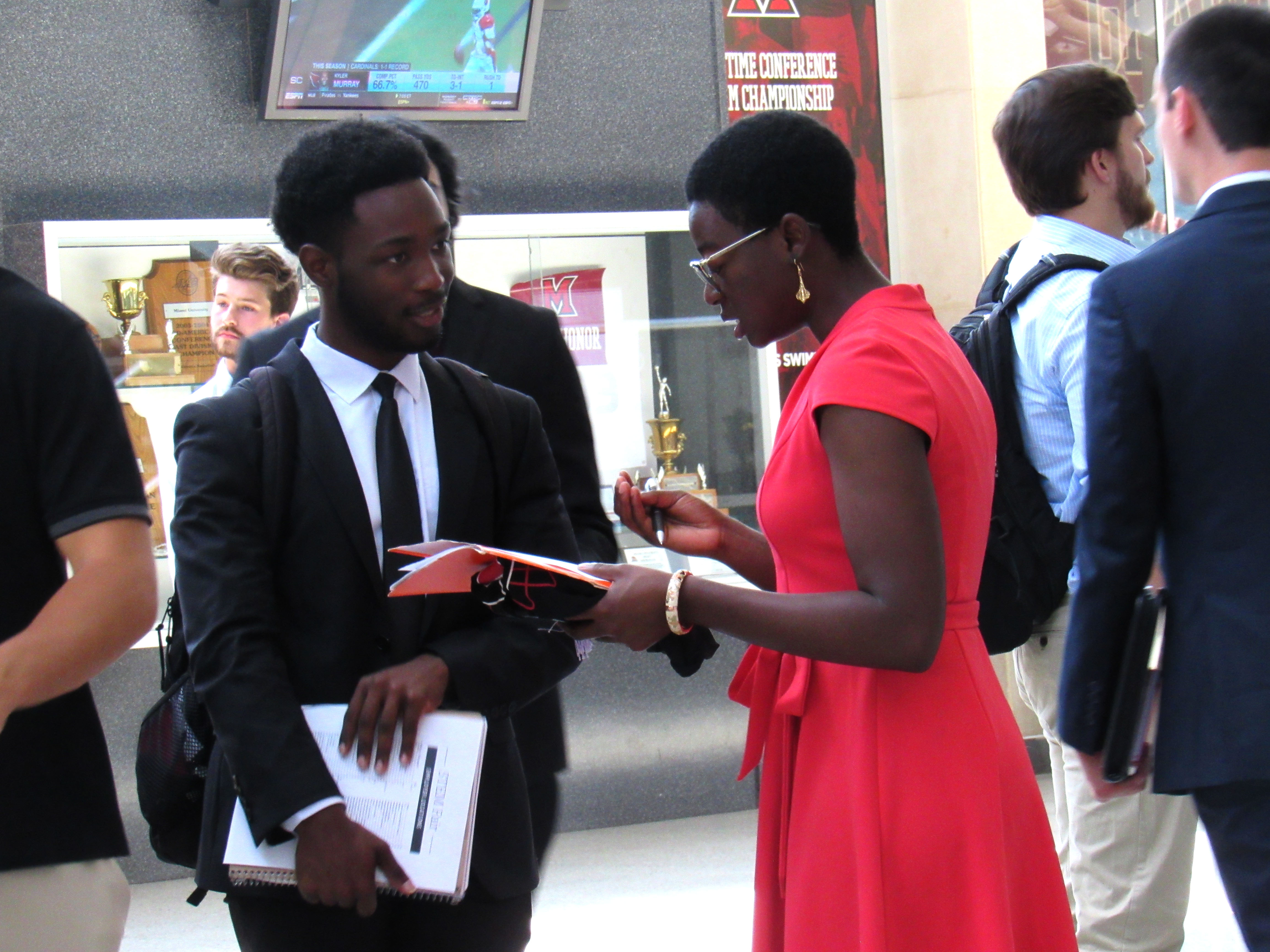 An employer reviews a resume with a student at a career fair.