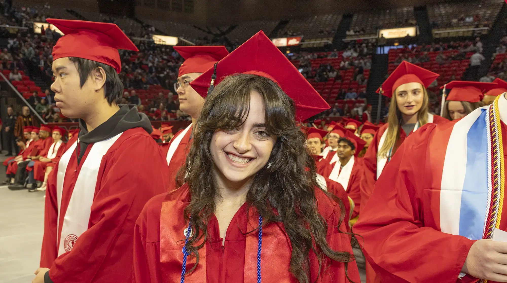 A graduate smiles during a commencement ceremony.