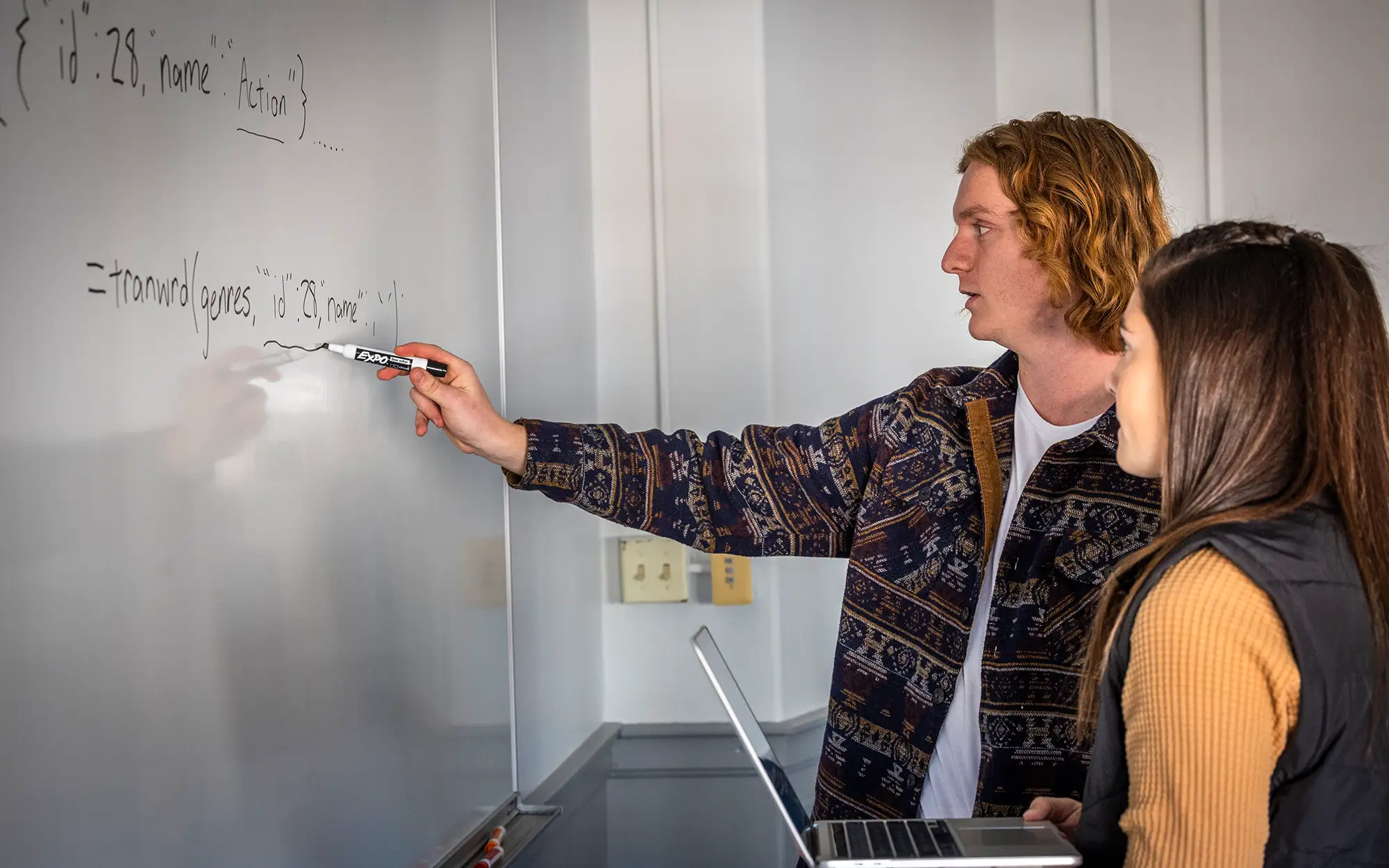Students working on data analysis on a whiteboard