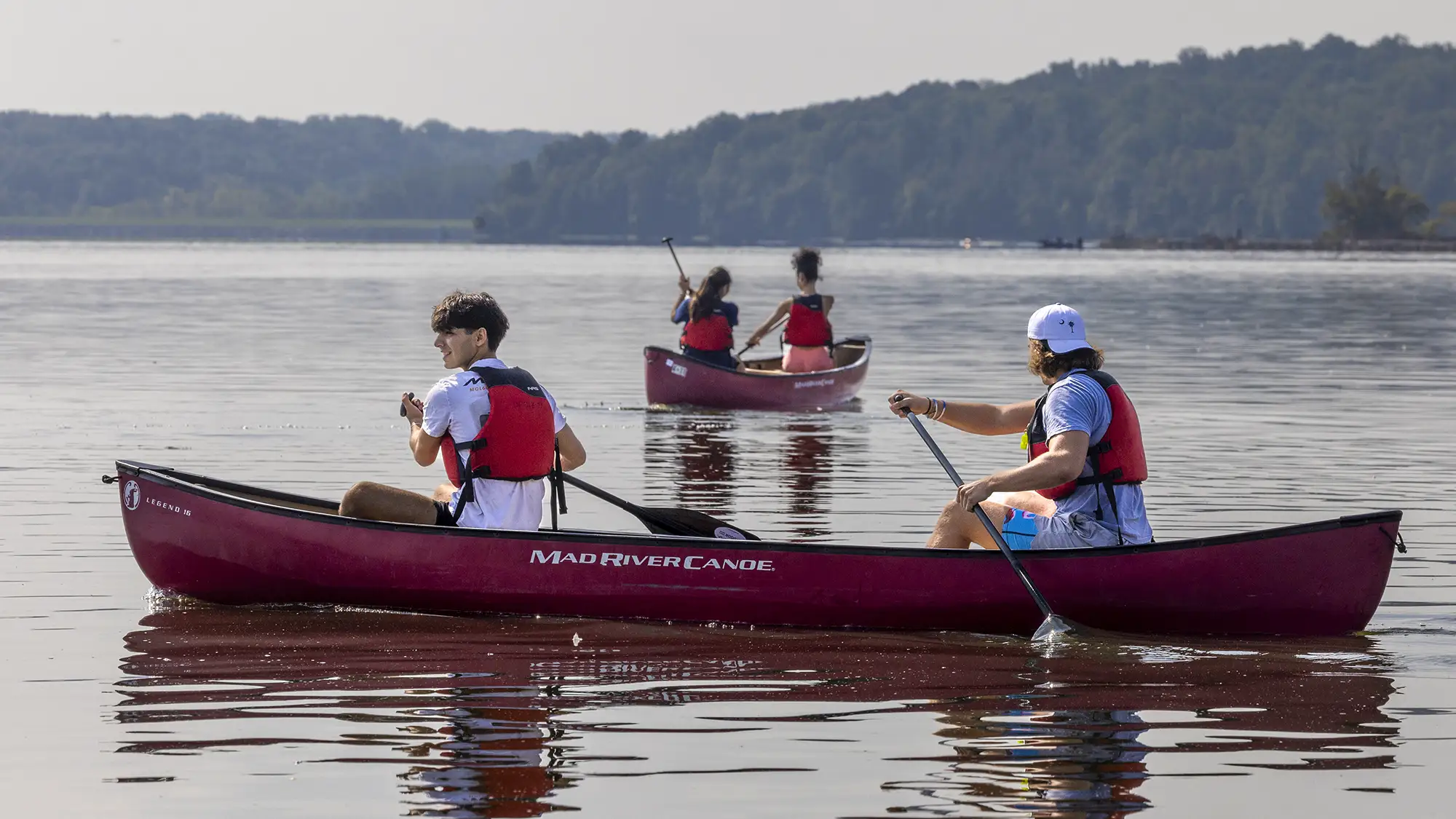 Students exploring a river on a canoe
