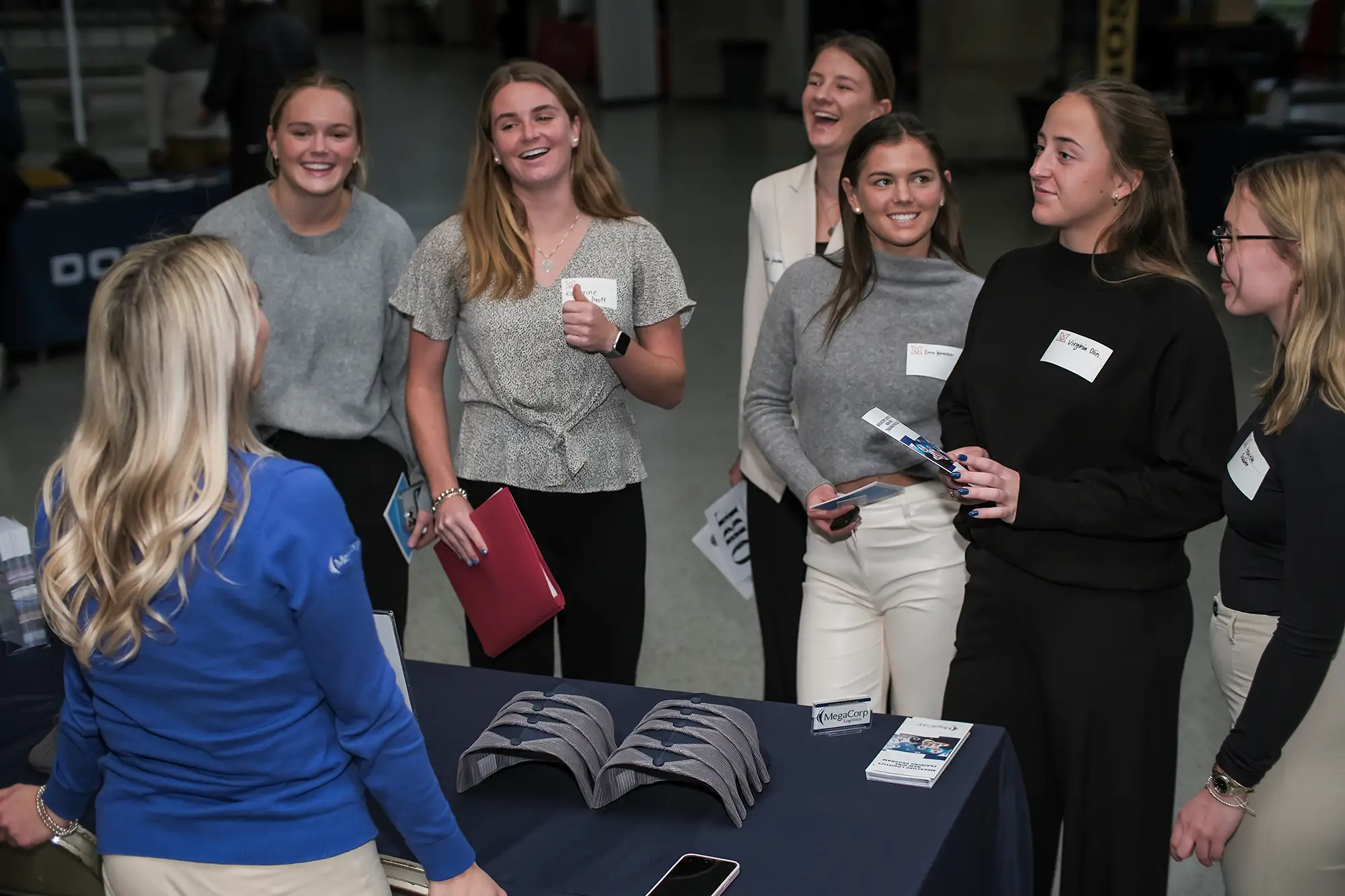 A group of students speak with an employer at a table.