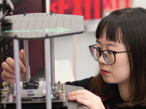 Female student engaged with a project in an engineering lab.