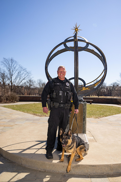 Police officer standing with a police dog at the sundail