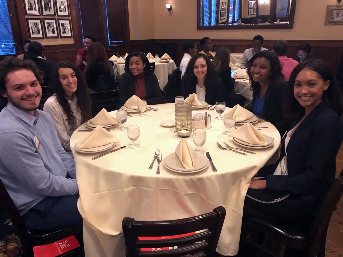 Miami students posing for a photo while at dinner
