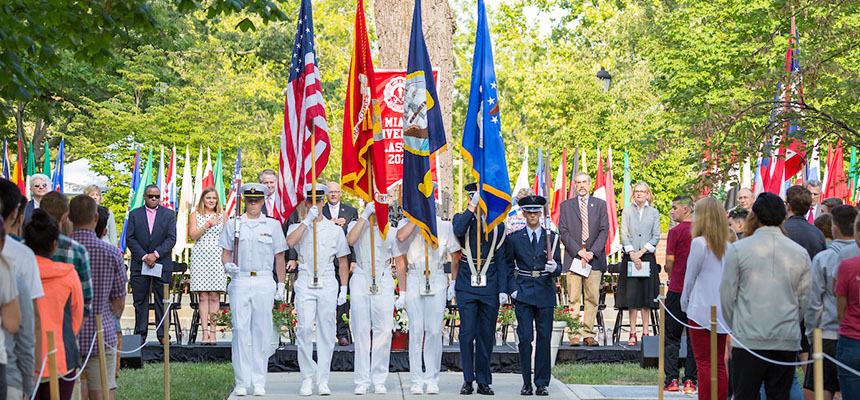 A ROTC color guard stands at attention at a commencement ceremony.
