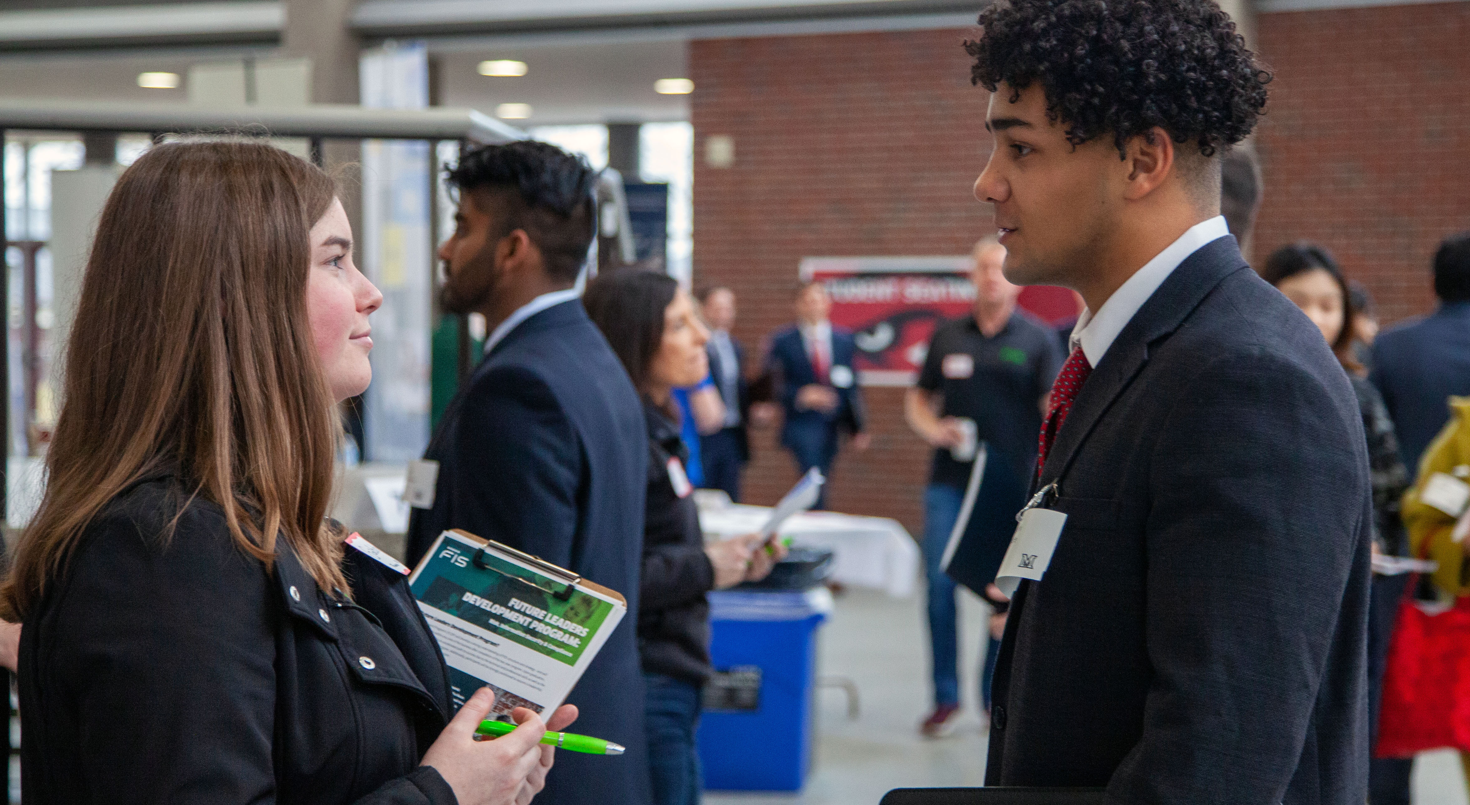 A student talking to a business rep at a career fair.