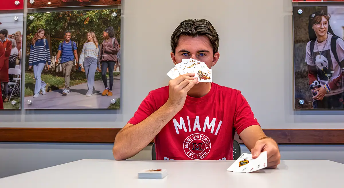 Photo of a student with playing cards