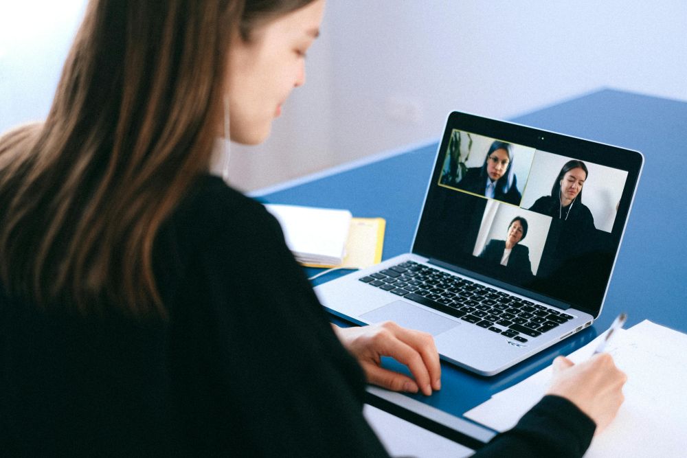 A person interviews over Zoom, with three people visible on the computer screen.