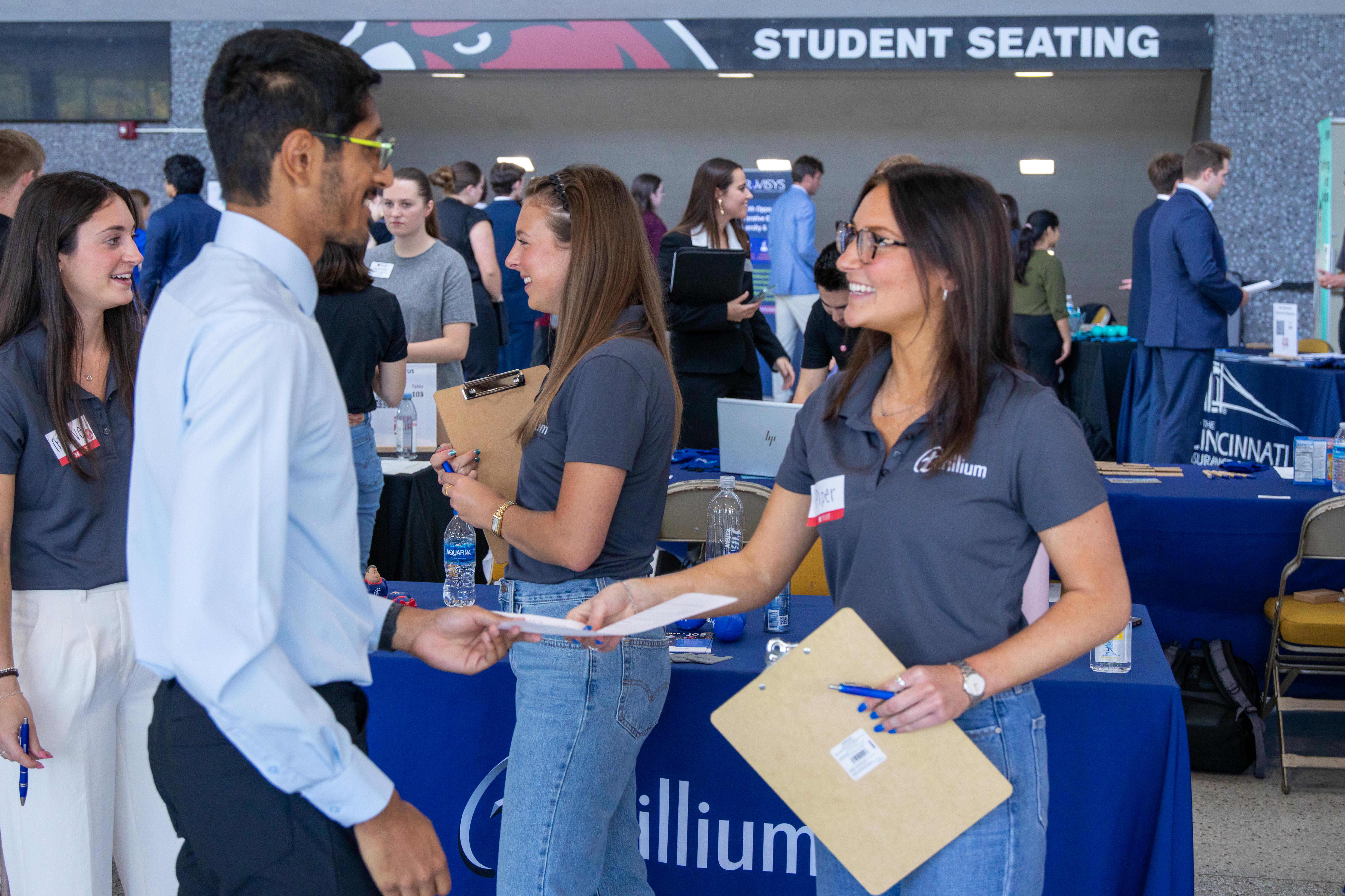 An employer shakes hands with a student at a career fair.