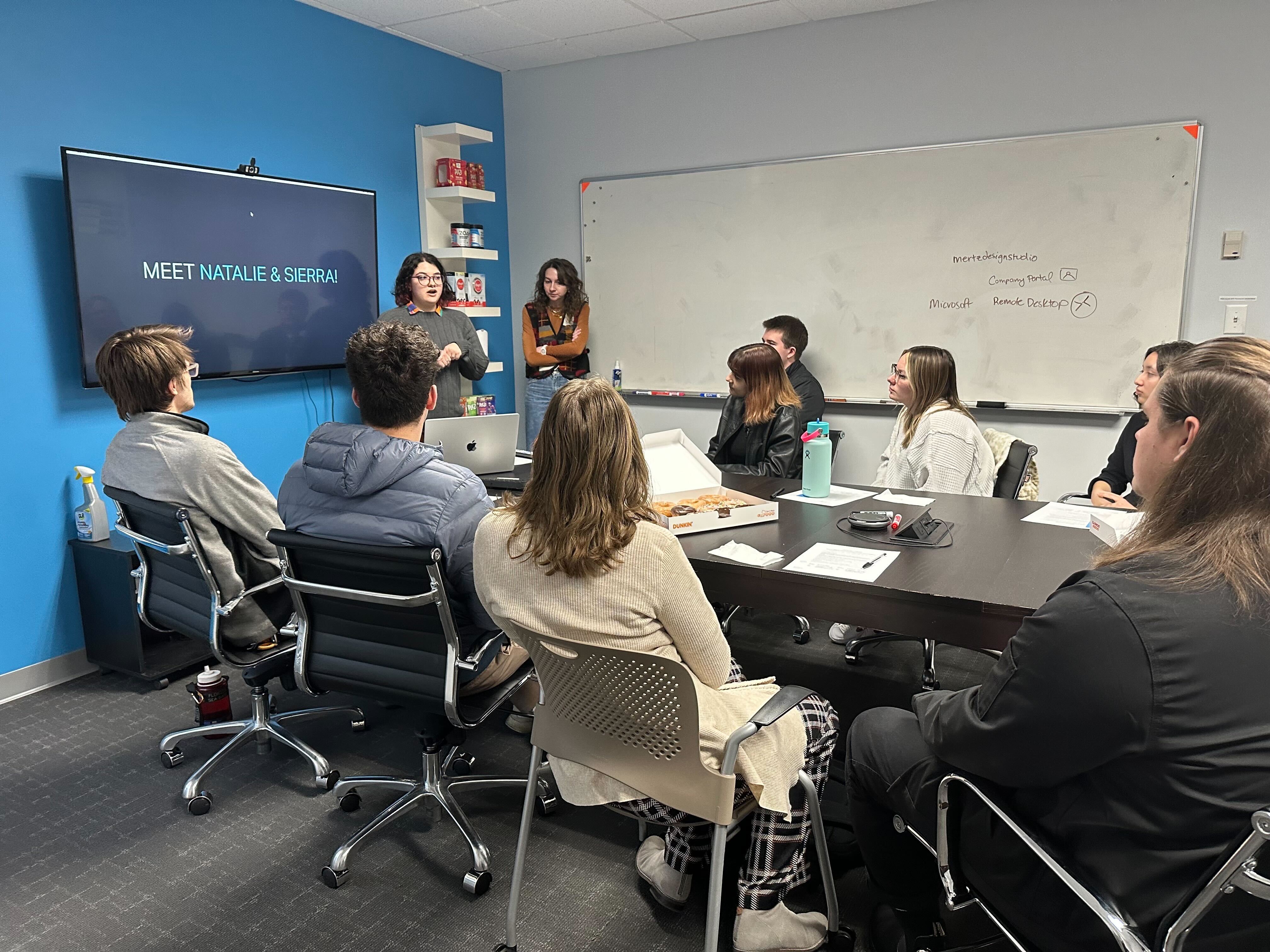 Two students present in a conference room at a job-shadow experience.