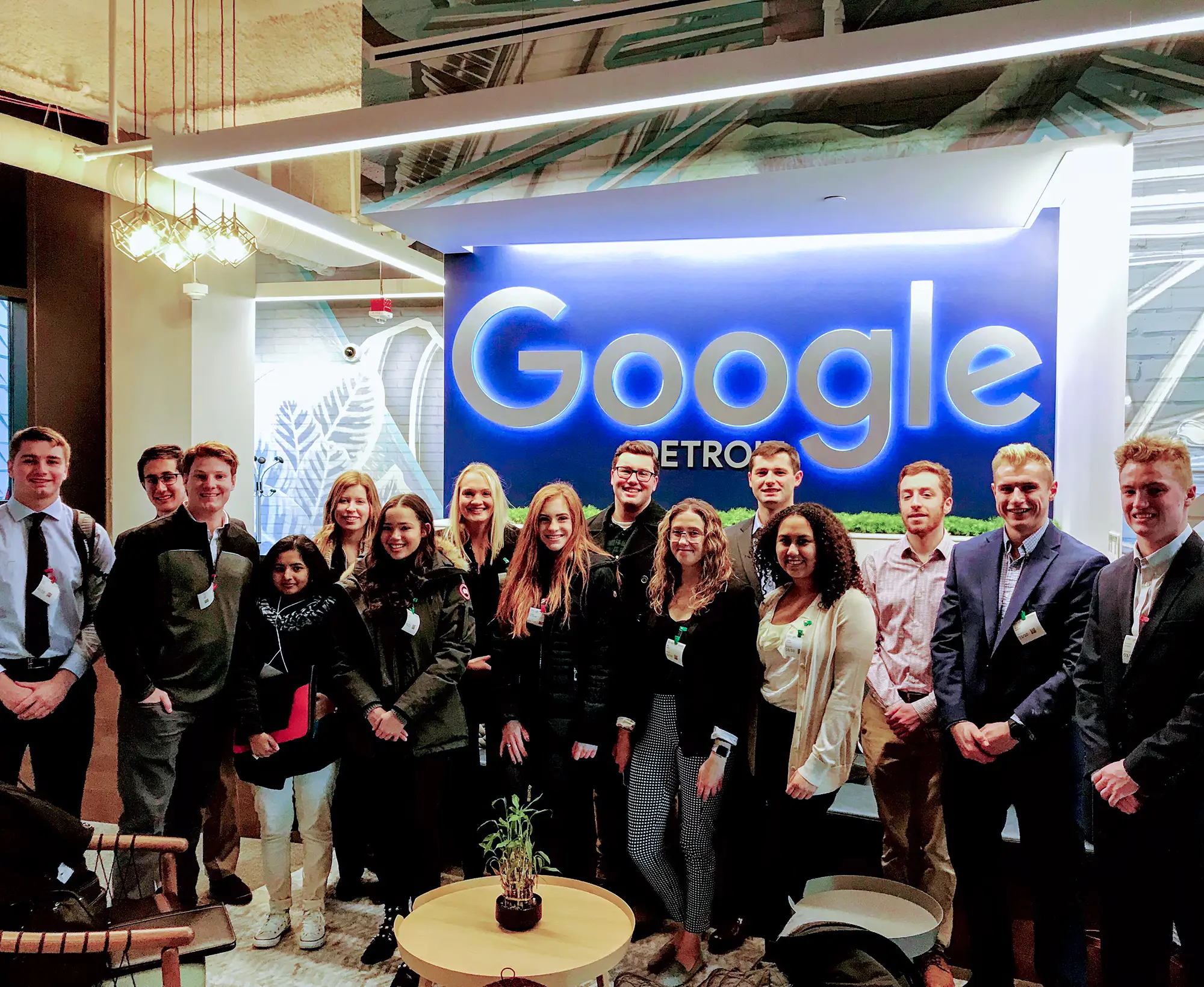 Group photo of Miami students posing beneath the Google logo at an employer visit
