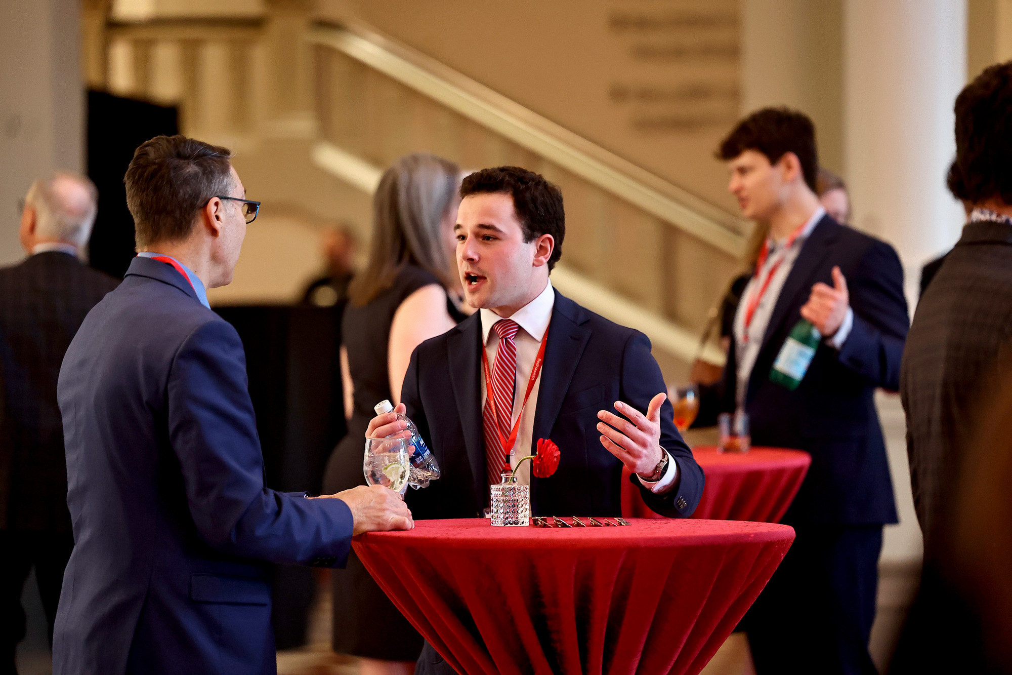 A student speaks with an alumni at a reception.