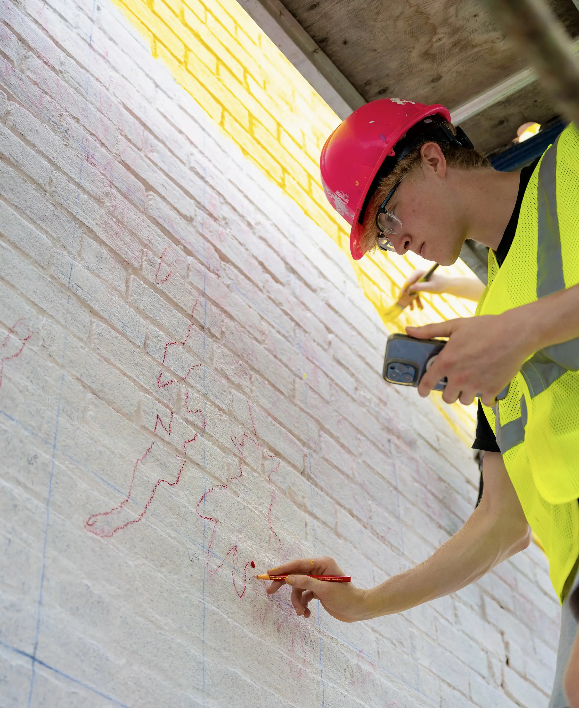 Riley Johnson works on a mural in Cincinnati with Artworks.