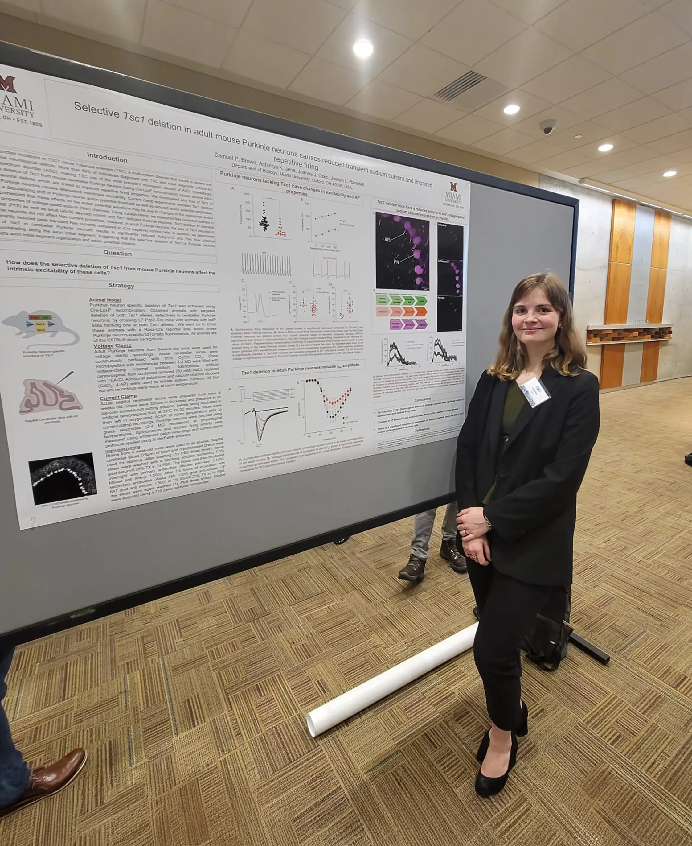 Joanna Osko stands in front of a poster board at a research event.