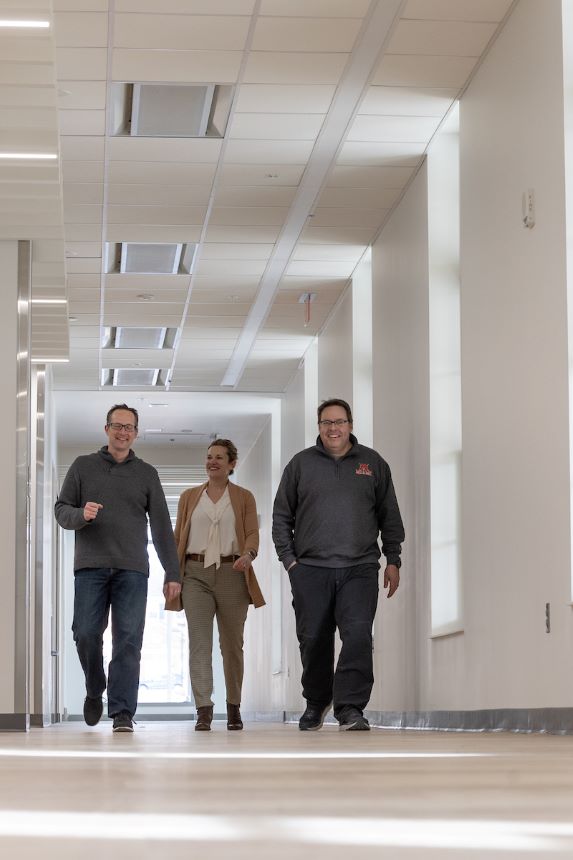 Faculty members walk through a hallway.