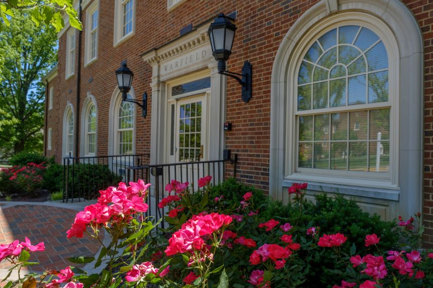 Front of Warfield Hall with pink flowers.