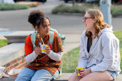 Two students on campus talking.