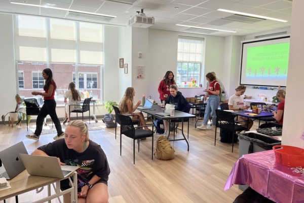 The Wellness Studio, with a handful of students at various tables and small stations across the room.