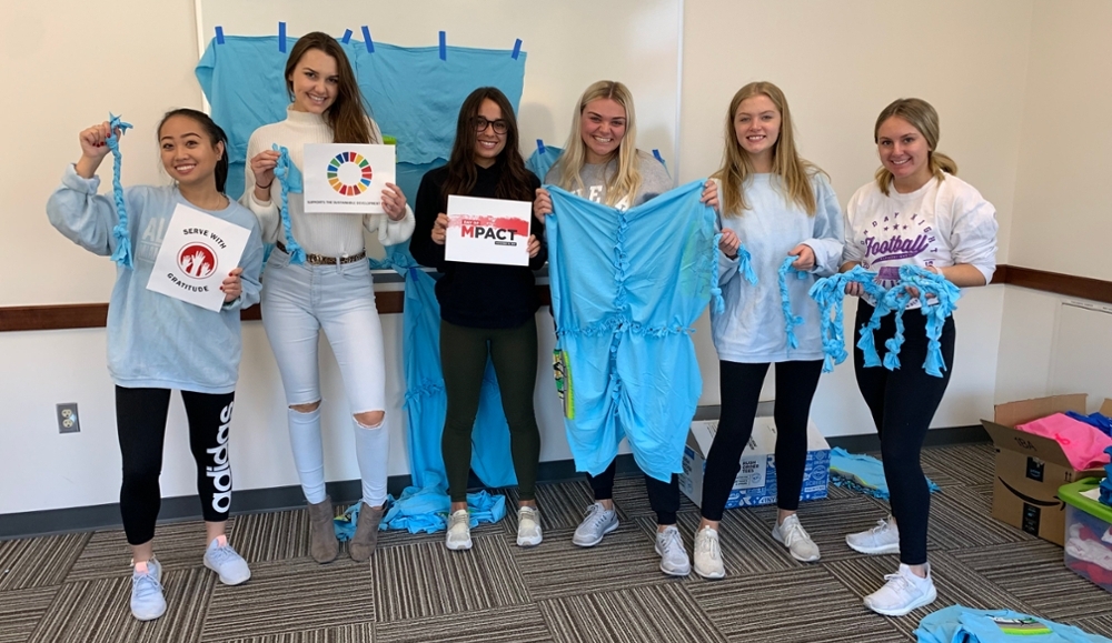 6 Students at MPACT, hoding up dog toys made from recycled t-shirts