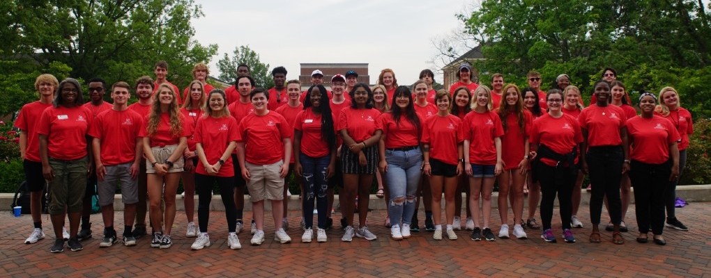 Large group of students in posed picture on campus; all wearing red shirts.