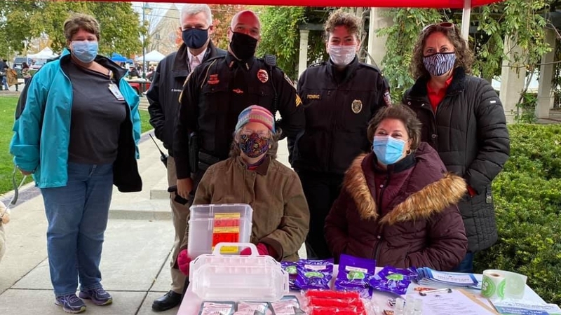 Oxford Police officers and community members under a red tent for a drug-take back day