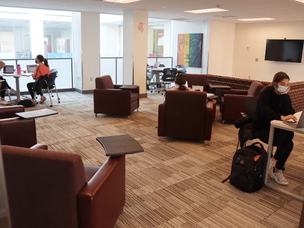 Large space with several armchairs, couches, and tables set up for individual and group gatherings.
