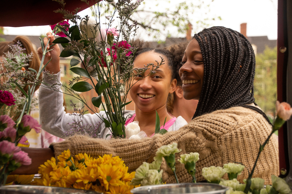 Two students picking out flowers from a flower truck on central quad at the Bloom with MAP event.