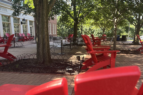 Armstrong terrace with red adirondack chairs spead througout.