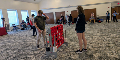 Two students playing a giant connect four game.