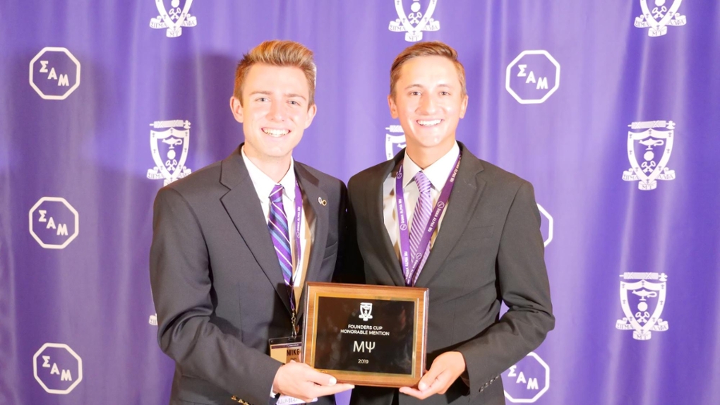 Sigma Alpha Mu Leaders holding their Founders Cup Honorable Mention award.