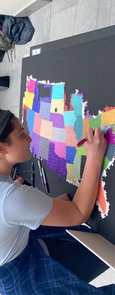 Student writing her name on a puzzle piece as part of the Census puzzle pledge