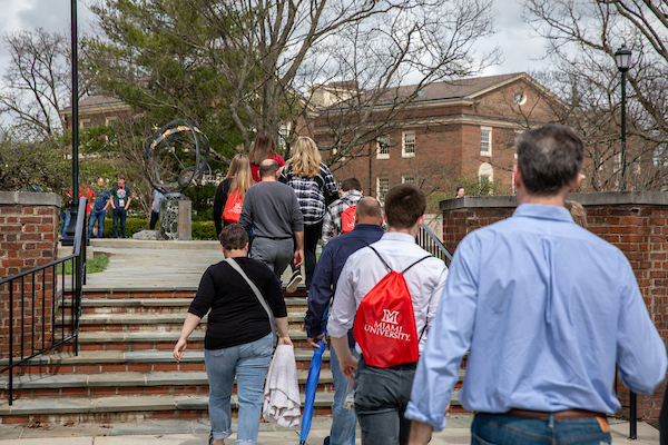 A group of people on a tour walk up the steps to the Tri-Delta Sundial.