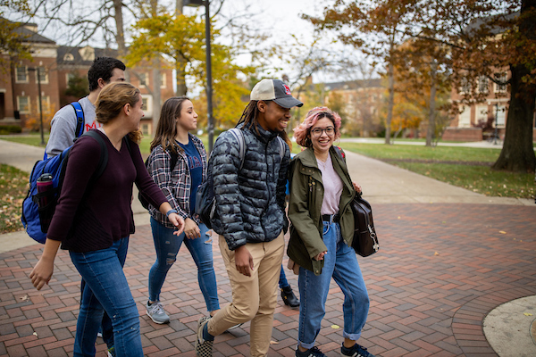 A group of five students walk to class together.