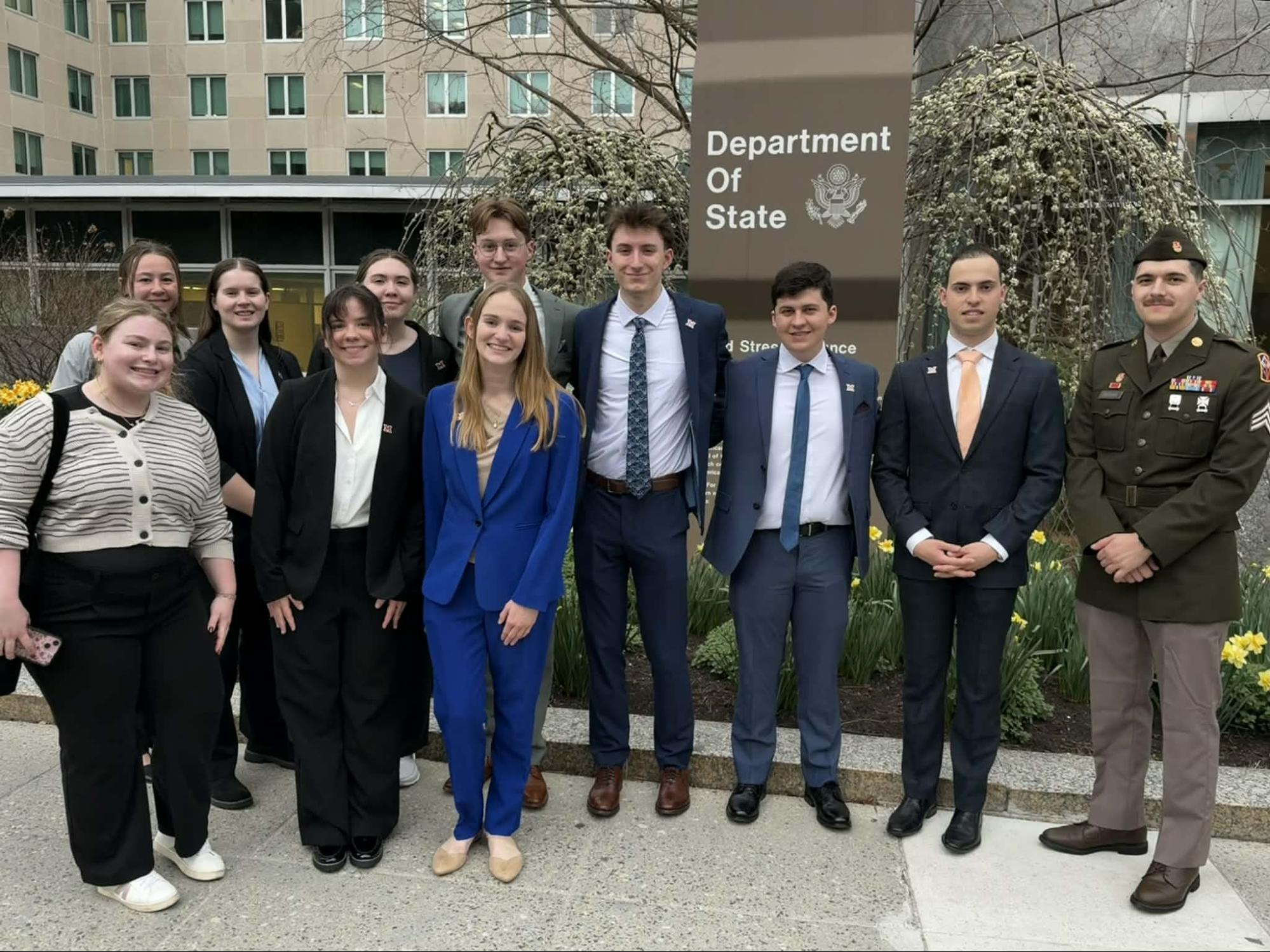 Group of students standing in front of the Department of State sign