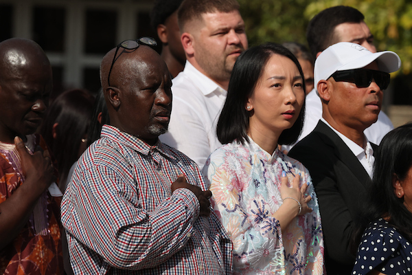 Man and woman with had over their heart as they say the pledge allegiance 