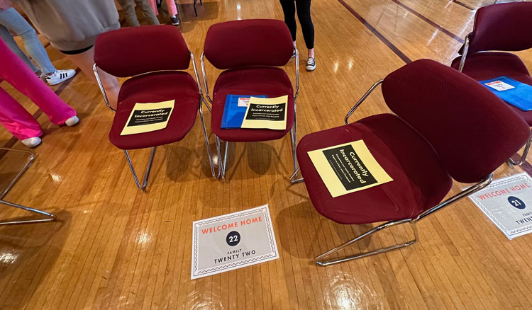3 chairs in a circle with yellow signs reading "Incarcerated Person"